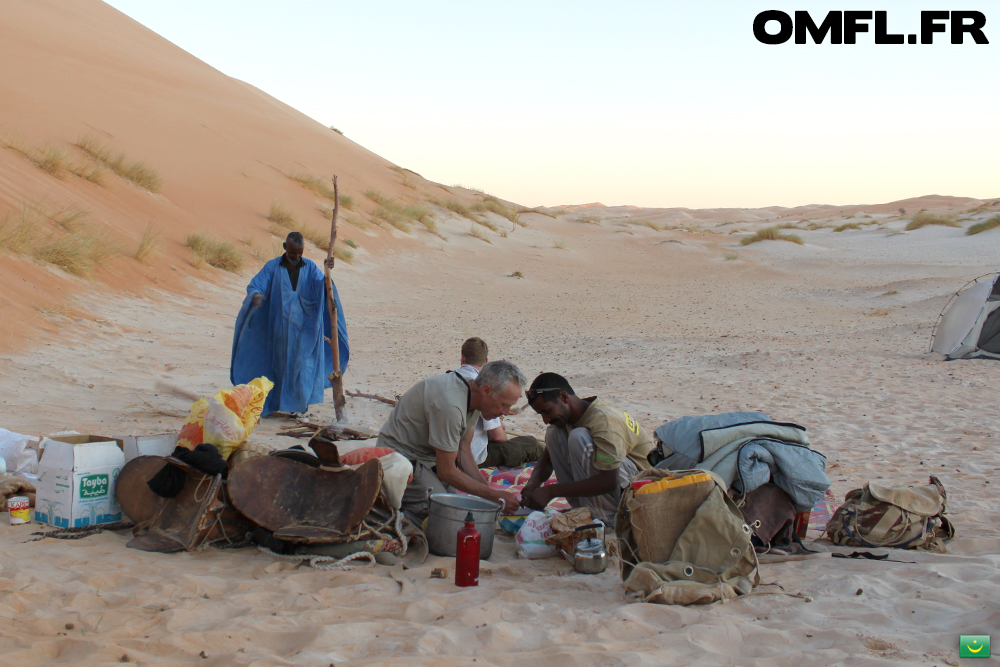 Jacques et Sidi découpent la viande pour le repas dans le desert